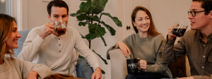 A group of friends enjoying Wolf Coffee and each other's company on couches with a plant on the ground.